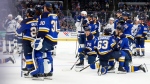 Members of the St. Louis Blues and the Tampa Bay Lightning wait on the ice outside of the players bench area while St. Louis Blues' Dylan Holloway, not pictured, is being tended to by medical personnel after receiving an injury during the first period of an NHL hockey game Tuesday, Nov. 5, 2024, in St. Louis. (AP / Scott Kane)