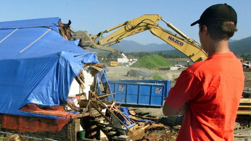 A construction shovel demolishes the Pickton farm house on the pig farm in Port Coquitlam, B.C. Saturday July 26, 2003. The B.C. Supreme Court says it has jurisdiction to order the disposal of thousands of pieces of evidence seized from Robert Pickton's pig farm decades ago, whether it was used in his murder trial or not. CP PHOTO/Chuck Stoody