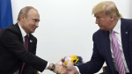 Then-U.S. president Donald Trump, right, shakes hands with Russian President Vladimir Putin, left, during a bilateral meeting on the sidelines of the G-20 summit in Osaka, Japan on June 28, 2019. (AP Photo/Susan Walsh)