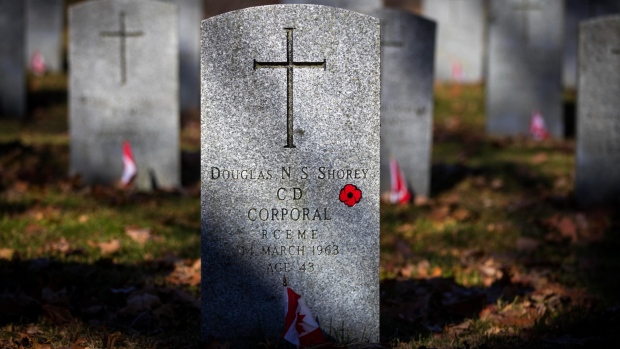 Flags are placed at soldiers' graves at Cataraqui Cemetery in Kingston, Ont., on Tuesday, Nov. 10, 2020. THE CANADIAN PRESS/Lars Hagberg