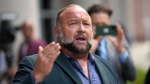 Right-wing conspiracy theorist Alex Jones speaks to the media after arriving at the federal courthouse for a hearing in front of a bankruptcy judge, June 14, 2024, in Houston. (AP Photo/David J. Phillip)