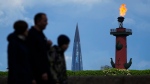 People walk along the Neva River embankment past the headquarters of Russian gas monopoly Gazprom skyscraper in St. Petersburg, Russia, Saturday, May 27, 2023. (AP Photo/Dmitri Lovetsky)