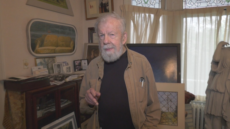 Nova Scotia artist Tom Forestall is pictured among paintings.