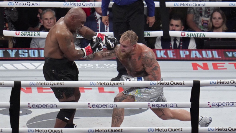 Jake Paul hits Mike Tyson during their heavyweight boxing match, Friday, Nov. 15, 2024, in Arlington, Texas. (AP Photo/Julio Cortez)