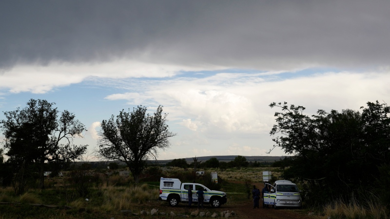 Police motor vehicles park near the opening of a reformed gold mineshaft where illegal miners are trapped in Stilfontein, South Africa, Monday, Nov. 18, 2024. (AP Photo/Themba Hadebe)