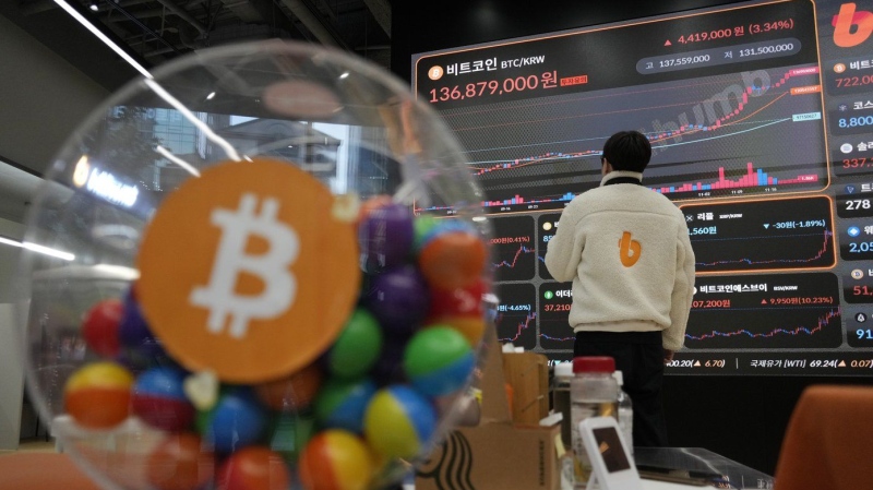 An employee watches an electronic signboard displaying the prices of Bitcoin and other cryptocurrencies at the lounge of Bithumb cryptocurrency exchange in Seoul, South Korea, Thursday, Nov. 21, 2024. (AP Photo/Ahn Young-joon)