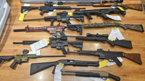 Several weapons are laid out on a table as part of an ongoing Ontario Provincial Police and Waterloo Regional Police Service investigation (Courtesy: Ontario Provincial Police)