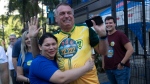 A supporter hugs former Brazilian President Jair Bolsonaro, centre, as he supports for Rio de Janeiro mayoral candidate Alexandre Ramagem during municipal elections in Rio de Janeiro, Sunday, Oct. 6, 2024. (AP Photo/Bruna Prado) 