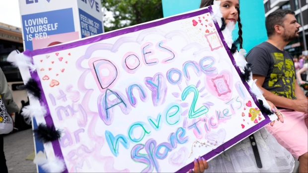 A fan of Taylor Swift holds a sign asking for tickets as she arrives at Wembley Stadium in London for the first of five concerts of Taylor Swift's Eras Tour, Thursday, Aug. 15, 2024. THE CANADIAN PRESS/AP-Alastair Grant