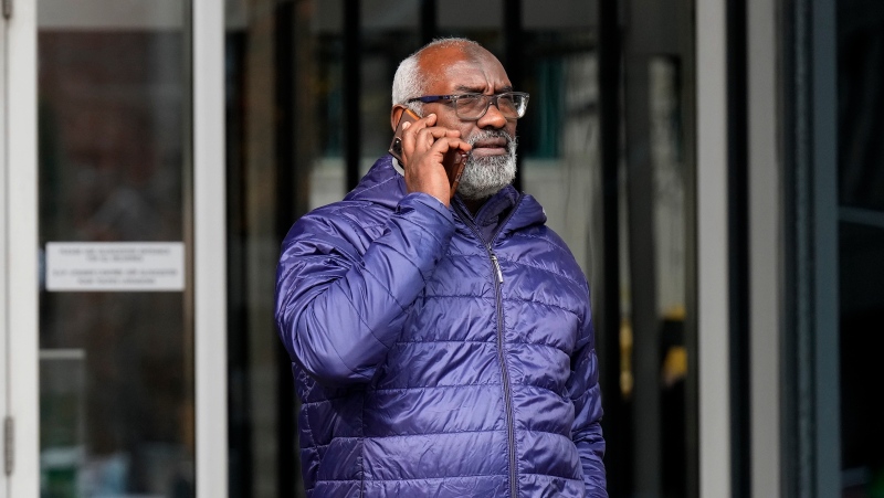 Abousfian Abdelrazik speaks on the phone as he leaves the a building where his case is being heard in Federal Court in Ottawa on October 30, 2024. (Adrian Wyld
/The Canadian Press)