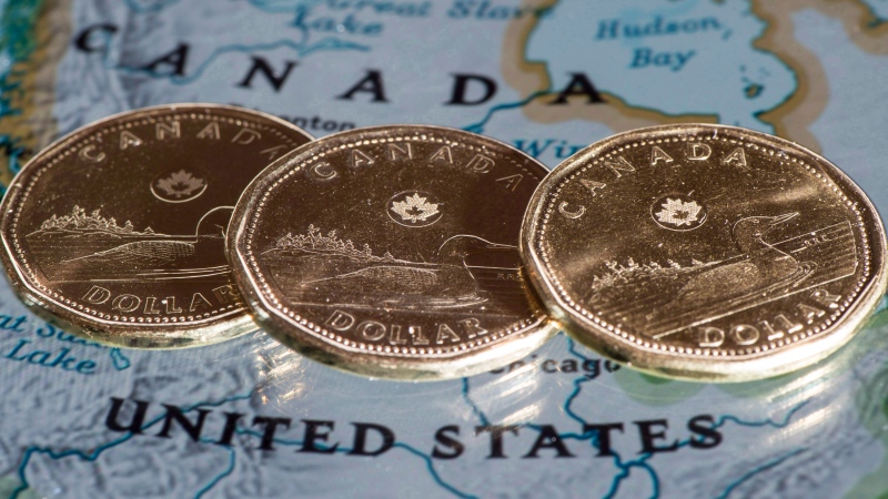 Canadian dollar coins, or loonies, are displayed on a map of North America in Montreal in a Thursday, Jan. 9, 2014, photo illustration. THE CANADIAN PRESS/Paul Chiasson
