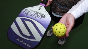 Head of Victoria regional pickleball association Connie McCann holds a polymer paddle and ball at Central Park court in Victoria, B.C., on Thursday, April 28, 2022. (THE CANADIAN PRESS/Chad Hipolito)