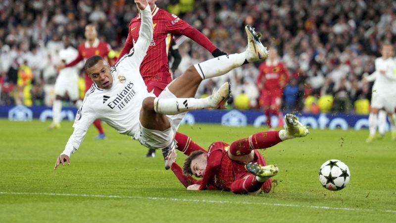 Liverpool's Conor Bradley tackles Real Madrid's Kylian Mbappe during the Champions League at Anfield Stadium, Liverpool, England, Wednesday, Nov. 27, 2024. (AP Photo/Jon Super)
