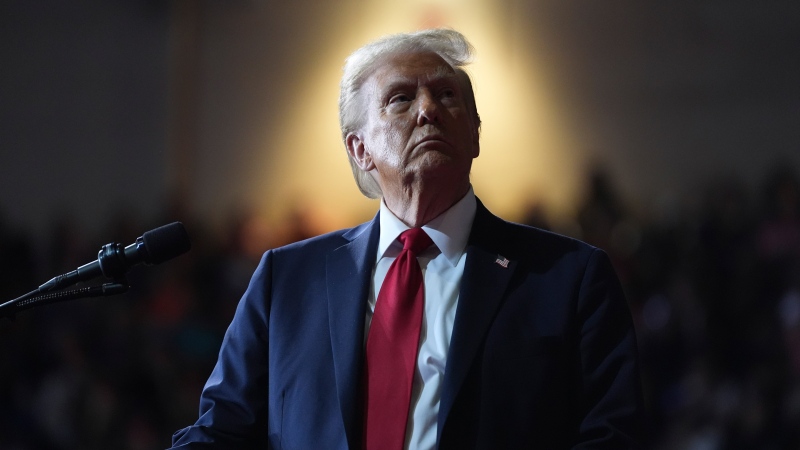 FILE - Republican presidential nominee former President Donald Trump watches a video screen at a campaign rally at the Salem Civic Center, in Salem, Va, Nov. 2, 2024. (AP Photo/Evan Vucci, File)