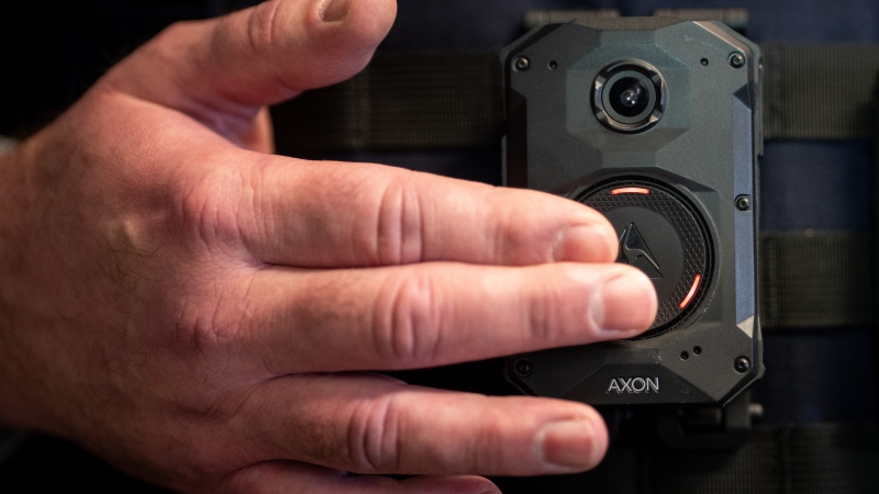 A Royal Canadian Mounted Police Officer turns off a body camera during a demonstration at a news conference in Surrey B.C., on Thursday, November 21, 2024. THE CANADIAN PRESS/Ethan Cairns