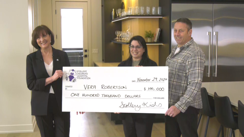 Karen Faulkner (left) presenting a cheque to Vera Robertson (middle) and John Robertson (right) on Friday, Nov. 29, 2024. (Darcy Seaton/CTV News Edmonton)