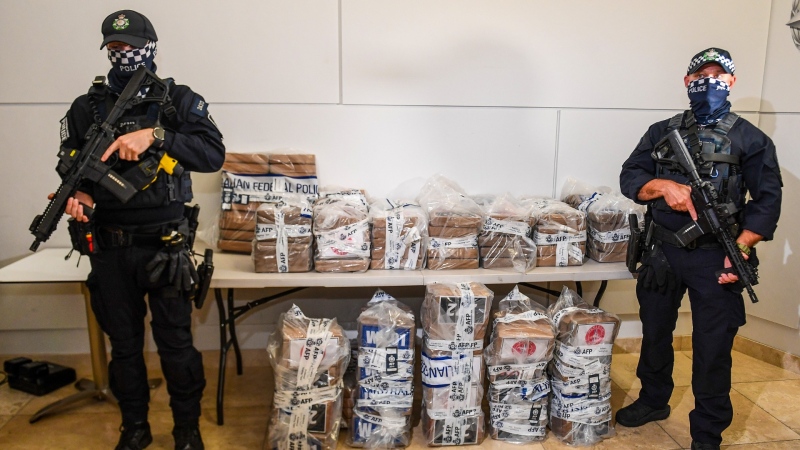 Australian Federal Police officers stand with approximately 350 kilograms (770 pounds) of seized cocaine at a press conference at the AFP headquarters in Brisbane, Australia, Dec. 2, 2024. (Jono Searle/AAP Image via AP)