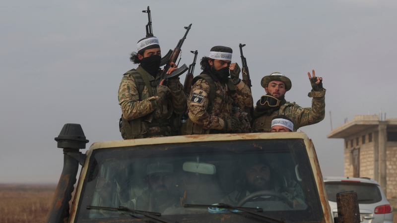 Syrian opposition fighters ride in a truck in Talhiya, Idlib countryside, Syria, Friday, Nov. 29, 2024. (AP Photo/Ghaith Alsayed)
