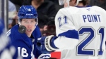 Toronto Maple Leafs right wing Mitch Marner keeps his eye on the puck as Tampa Bay Lightning centre Brayden Point looks on during NHL hockey action on Oct. 21, 2024. (THE CANADIAN PRESS/Frank Gunn)