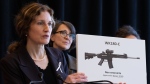 Heidi Rathjen, coordinator of PolySeSouvient, holds a sign showing a gun during a press conference about stricter gun control in Montreal on November 19, 2024. THE CANADIAN PRESS/Christinne Muschi