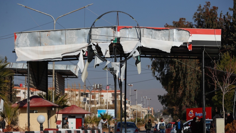 Syrian opposition fighters man a checkpoint in Damascus, Syria, Monday Dec. 9, 2024. (AP Photo/Omar Sanadiki)
