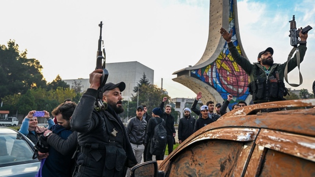 Anti-government fighters celebrate at Umayyad Square in Damascus on December 8. (Louai Beshara / AFP)