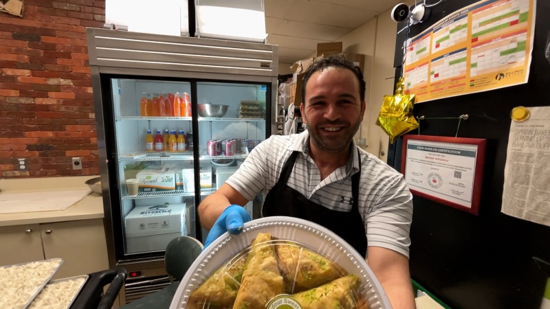 Aeman Alkadour celebrating the fall of the Assad regime in Syria at his Ottawa bakery. Dec. 9, 2024 (Josh Marano, CTV Ottawa)