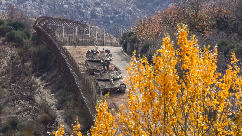 Israeli soldiers stand on the top of a tank near the so-called Alpha Line that separates the Israeli-annexed Golan Heights from Syria, in the town of Majdal Shams, Dec. 10, 2024. (AP Photo/Matias Delacroix)