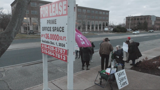 A small group of people rally outside the now closed WSIB offices on Ouellette Avenue in Windsor on Dec. 9, 2024. (CTV News file image)