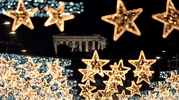 The Doric columns of the floodlit, 5th Century BC Parthenon Temple on the Acropolis appear behind strings of Christmas street lights, in Athens, Greece, Monday, Dec. 9, 2024. (AP Photo/Thanassis Stavrakis)