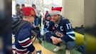 Winnipeg Jets captain Adam Lowry talks with a kid during a holiday visit by the team to the Rehabilitation Centre for Children on Dec. 11, 2024. (Scott Andersson/CTV News Winnipeg)