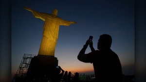 A tourist takes a photo of the Christ the Redeemer statue in Rio de Janeiro, Tuesday, Sept. 10, 2024. (AP Photo/Hannah-Kathryn Valles)