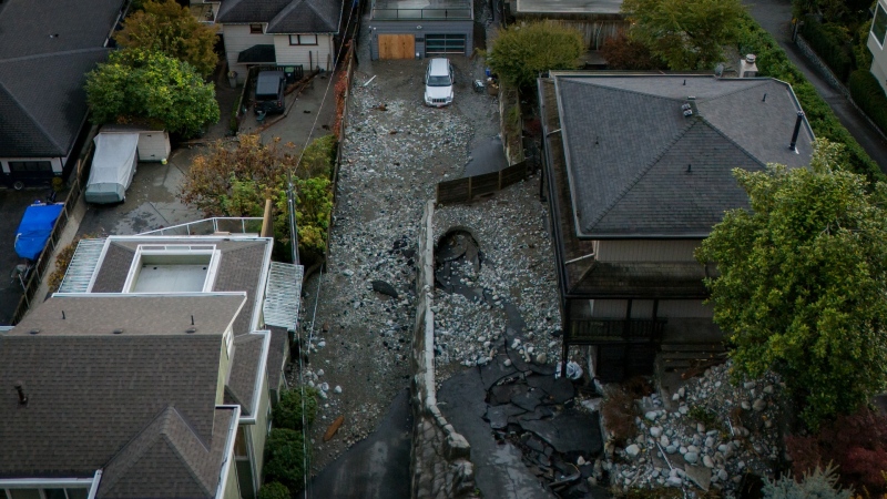 Multiple homes are seen surrounded by debris left by flooding from torrential rain from an atmospheric river weather system in Deep Cove in North Vancouver, on Oct. 22, 2024. (Ethan Cairns / The Canadian Press)