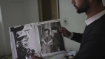 A man shows old pictures of the late Syrian President Hafez Assad as people search for belongings in the ransacked private residence of Syrian President Bashar Assad in the Malkeh district of Damascus, Syria, on Sunday, Dec. 8, 2024. (AP Photo/Ghaith Alsayed,File)