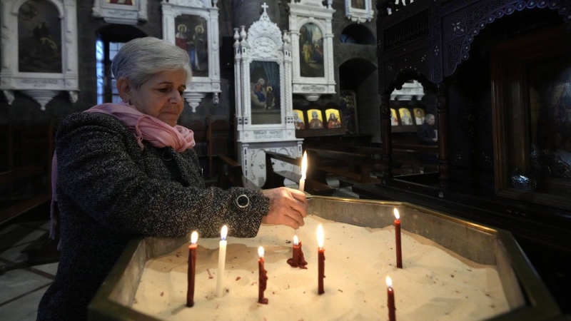 A Syrian woman lights a candle inside a church during the first Sunday Mass since Syrian President Bashar Assad's ouster, in old Damascus, Syria, Sunday, Dec. 15, 2024. (AP Photo/Hussein Malla)
