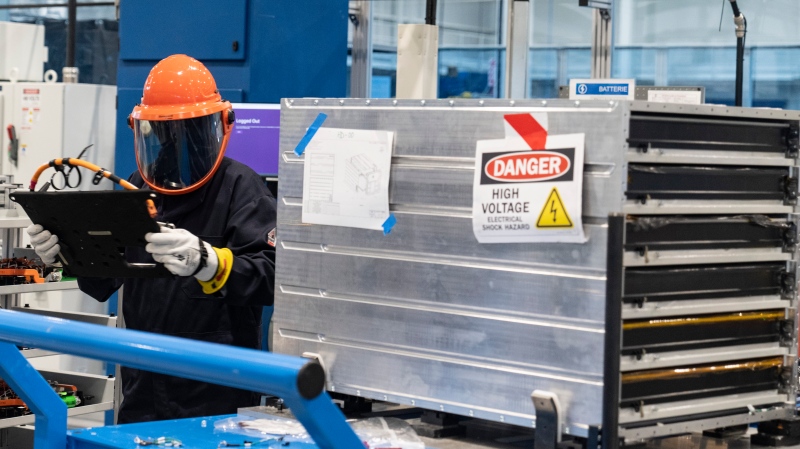 A worker installs an installation plate into a battery pack at Lion Electric's lithium-ion battery manufacturing facility in Mirabel, Que., Thursday, Sept. 14, 2023. (THE CANADIAN PRESS/Christinne Muschi)