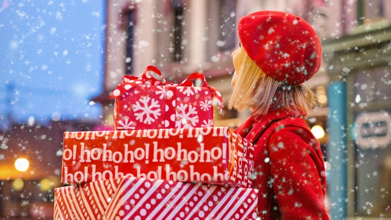 A woman holds presents in this undated stock image. (Jill Wellington/Pexels.com)