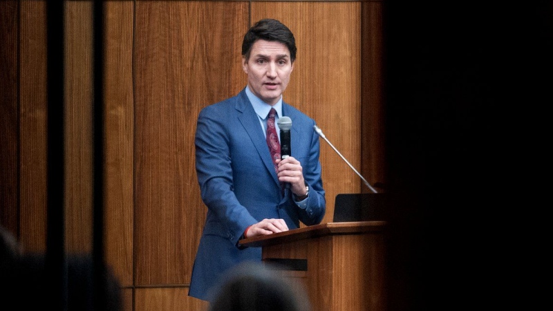 Prime Minister Justin Trudeau is pictured through glass as he speaks with members of his caucus in Ottawa, on Monday, Dec. 16, 2024. THE CANADIAN PRESS/Spencer Colby