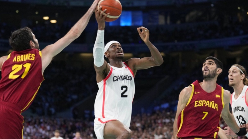 Shai Gilgeous-Alexander, of Canada, shoots between Alex Abrines (21) and Santi Aldama, of Spain, in a men's basketball game at the 2024 Summer Olympics, Friday, Aug. 2, 2024, in Villeneuve-d'Ascq, France. THE CANADIAN PRESS/AP-Mark J. Terrill