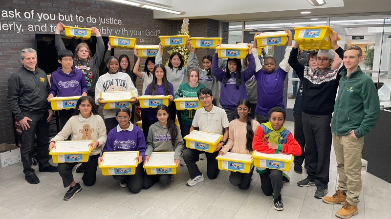 Assumption College Catholic Middle School students accept a donation of LEGO robotic kits from St. Clair College on Dec. 19, 2024. (Michelle Maluske/CTV News Windsor)