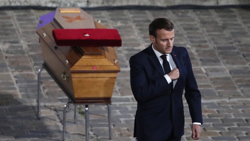 French President Emmanuel Macron leaves after paying his respects by the coffin of slain teacher Samuel Paty in the courtyard of the Sorbonne university during a national memorial event, Wednesday, Oct. 21, 2020 in Paris. (AP Photo/Francois Mori)