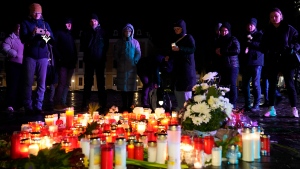 People light candles outside Magdeburg Cathedral after a memorial service for victims of Friday's Christmas Market attack, where a car drove into a crowd, in Magdeburg, Germany, Saturday, Dec. 21, 2024. (AP Photo/Ebrahim Noroozi)