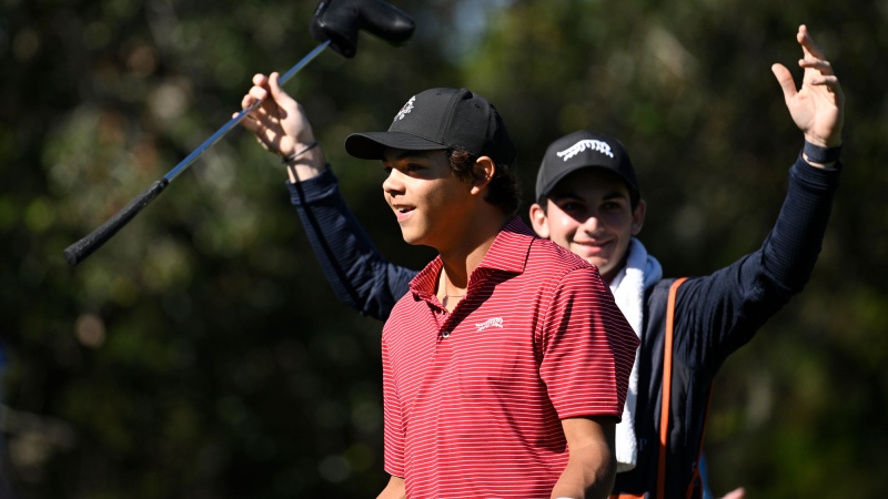 Charlie Woods, front, and his caddie Luke Wise react after his hole-in-one on the fourth hole during the final round of the PNC Championship golf tournament, Sunday, Dec. 22, 2024, in Orlando, Fla. (AP Photo/Phelan M. Ebenhack)