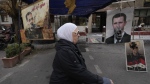 Shoes hanging in front of portraits of ousted Syrian President Bashar Assad in Damascus, Syria, Monday, Dec. 23, 2024. (AP Photo/Hussein Malla)