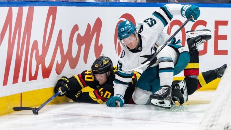 Vancouver Canucks' Elias Pettersson (40) and San Jose Sharks' Ty Dellandrea (53) vie for the puck during second period NHL hockey action in Vancouver, B.C., Monday, Dec. 23, 2024. THE CANADIAN PRESS/Ethan Cairns