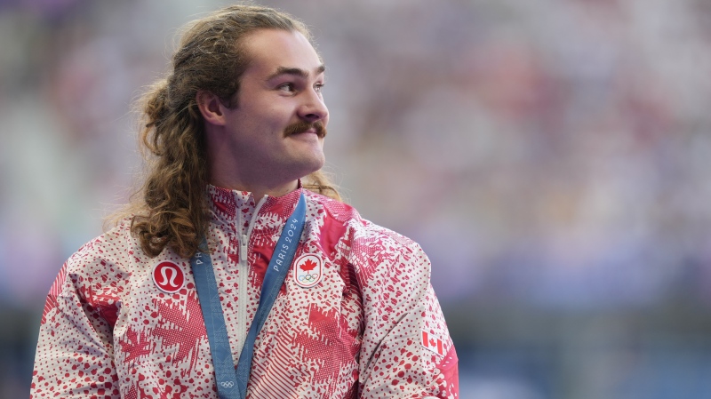 Ethan Katzberg, of Nanaimo, B.C., receives his gold medal in the men's hammer throw event at the 2024 Summer Olympics, in Saint-Denis, France, Monday, Aug. 5, 2024. THE CANADIAN PRESS/Christinne Muschi