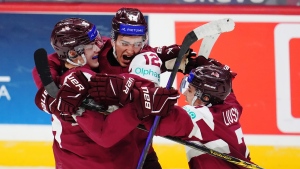 Latvia's Eriks Mateiko, left, celebrates his game-winning shootout goal against Canada with Toms Mots (12) and Davids Livsics (7) in IIHF World Junior Hockey Championship preliminary round action in Ottawa, Dec. 27, 2024. THE CANADIAN PRESS/Sean Kilpatrick