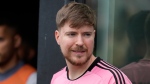 Jimmy Donaldson, the popular YouTube video maker who goes by MrBeast, wears a Lionel Messi jersey as he stands in a sideline box at the start of an MLS soccer match between Inter Miami and CF Montreal, March 10, 2024, in Fort Lauderdale, Fla. (AP Photo/Rebecca Blackwell, File)