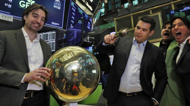 GFL Environmental CEO Patrick Dovigi, second left, is joined by BC Partners Paolo Notarnicola, left, as he rings a ceremonial bell on the floor of the New York Stock Exchange, Wednesday, March 4, 2020. THE CANADIAN PRESS/AP/Richard Drew