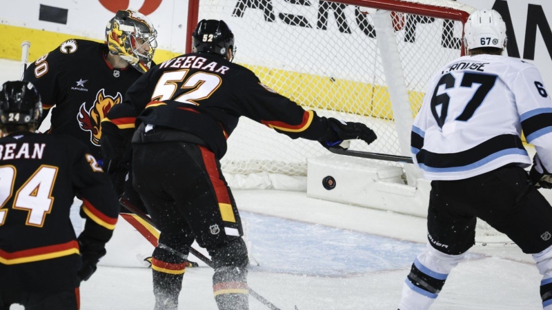 The Utah Hockey Club's Lawson Crouse, right, scores on Calgary Flames goalie Dan Vladar in Calgary on Jan. 2, 2025. THE CANADIAN PRESS/Jeff McIntosh